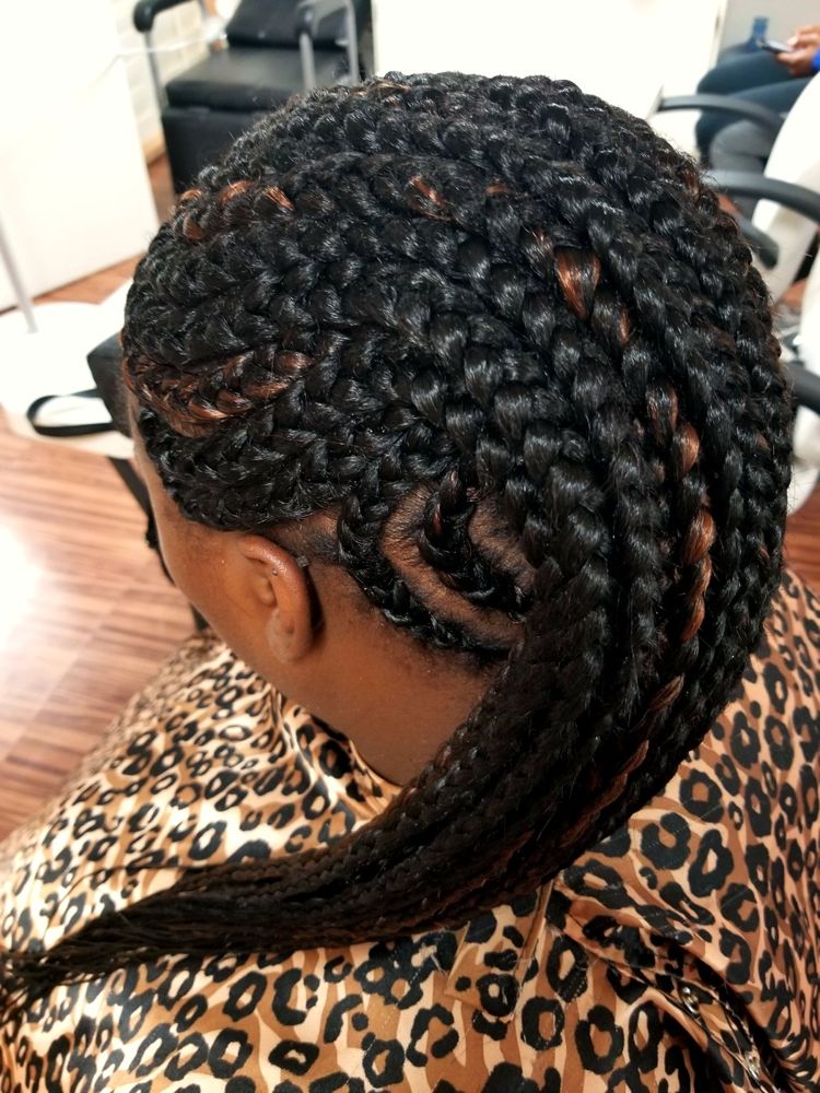 Cornrows swept to the side, seen from behind